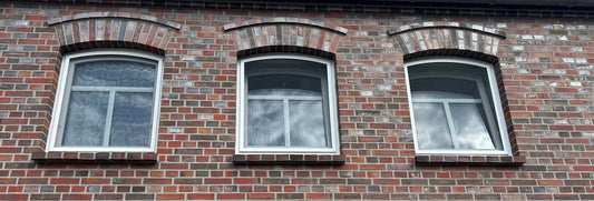 Drei Stichbogenfenster mit Fliegengittern im eingebauten Zustand
